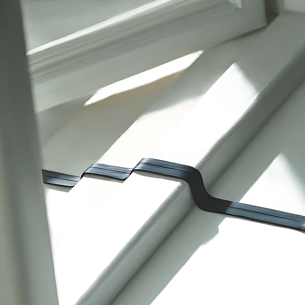 Aufgewickeltes, flaches Anderson zu Anderson Kabel; schwarz mit hellgrauem Stecker in Fensterrahmen zur Veranschaulichung